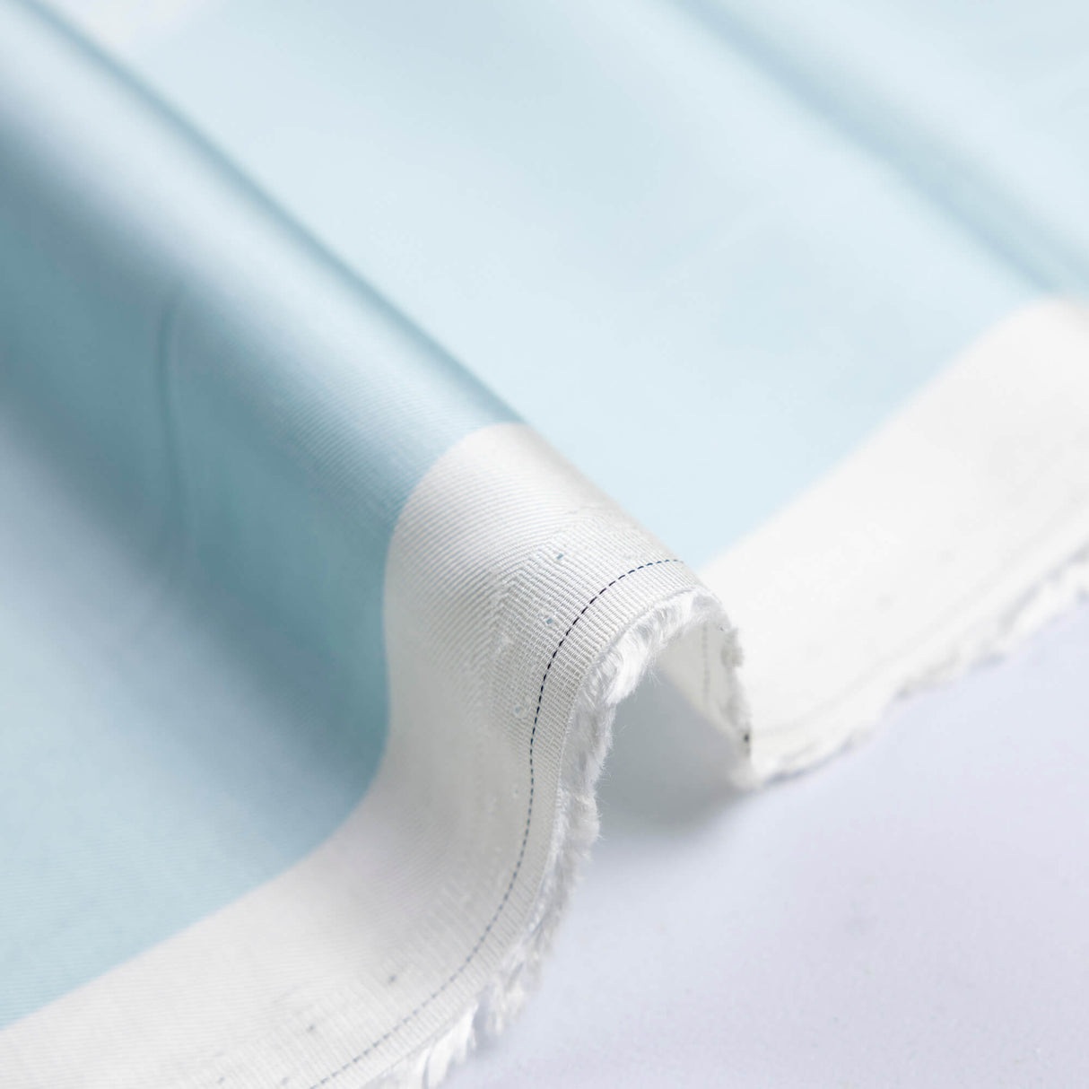 Twill 100% viscose – Fleurs blanches fond bleu ciel