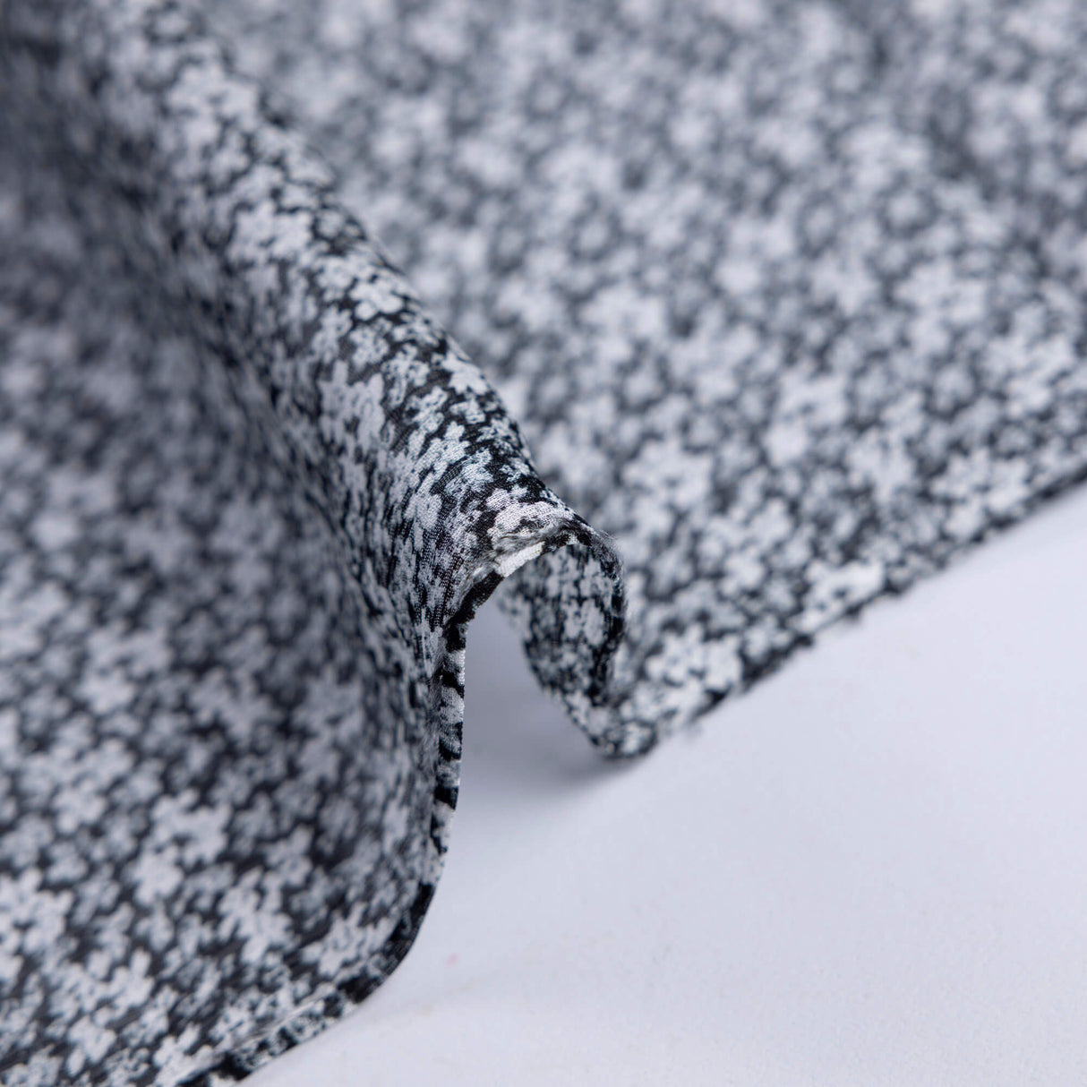 Mousseline 100% viscose – Micro fleurs blanches fond noir