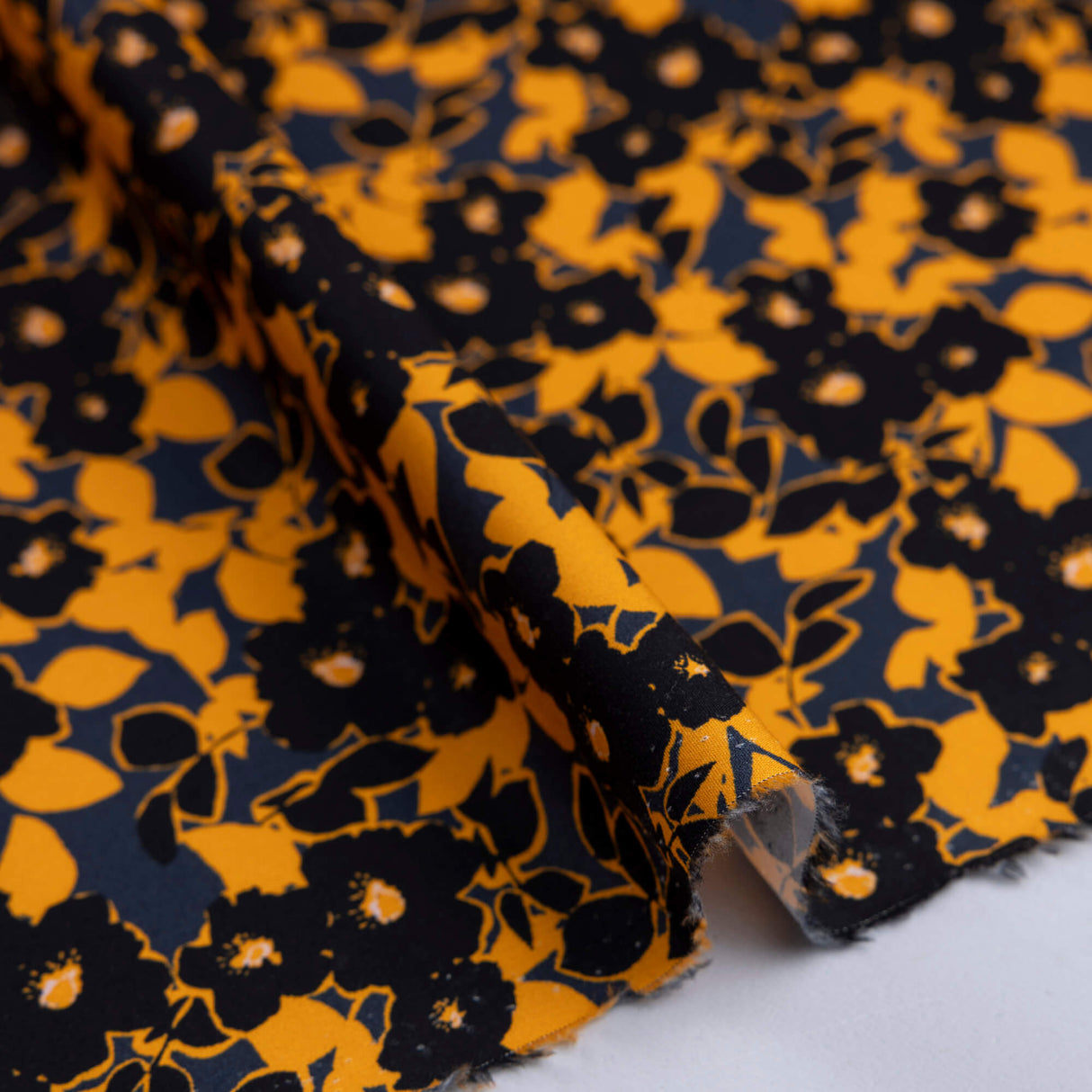 Popeline 100% coton – Fleurs noir et orange fond marine