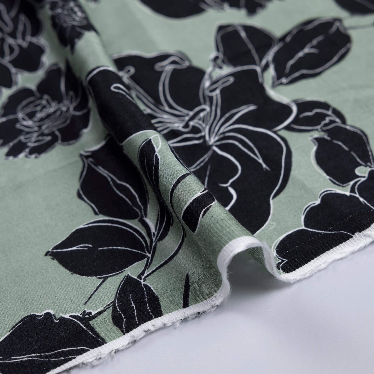 Satin 100% viscose – Fleurs noires fond vert sauge