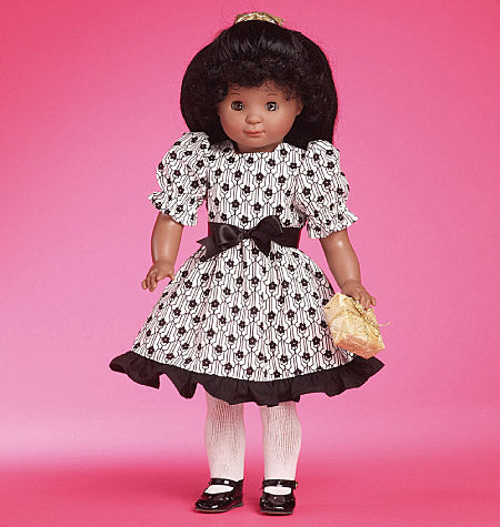 Poupée noire en robe à motifs noir et blanc, ceinture noire et bretelles, chapeau noir, socquettes blanches et chaussures noires, sur fond rose.