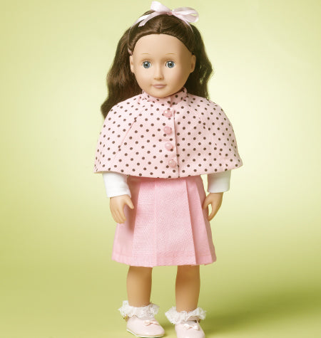 Poupée pour enfant avec robe rose et cape à pois, nœud rose dans les cheveux, pieds blancs satinés.