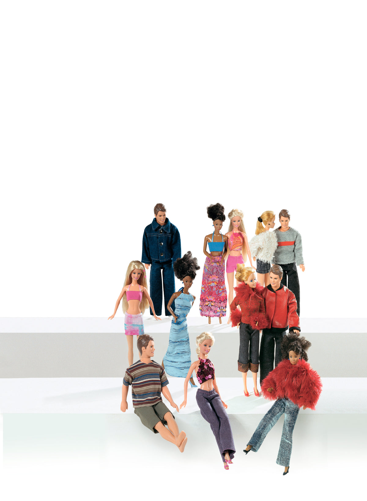 Groupe de poupées Barbie portant des tenues variées posant sur un fond blanc.