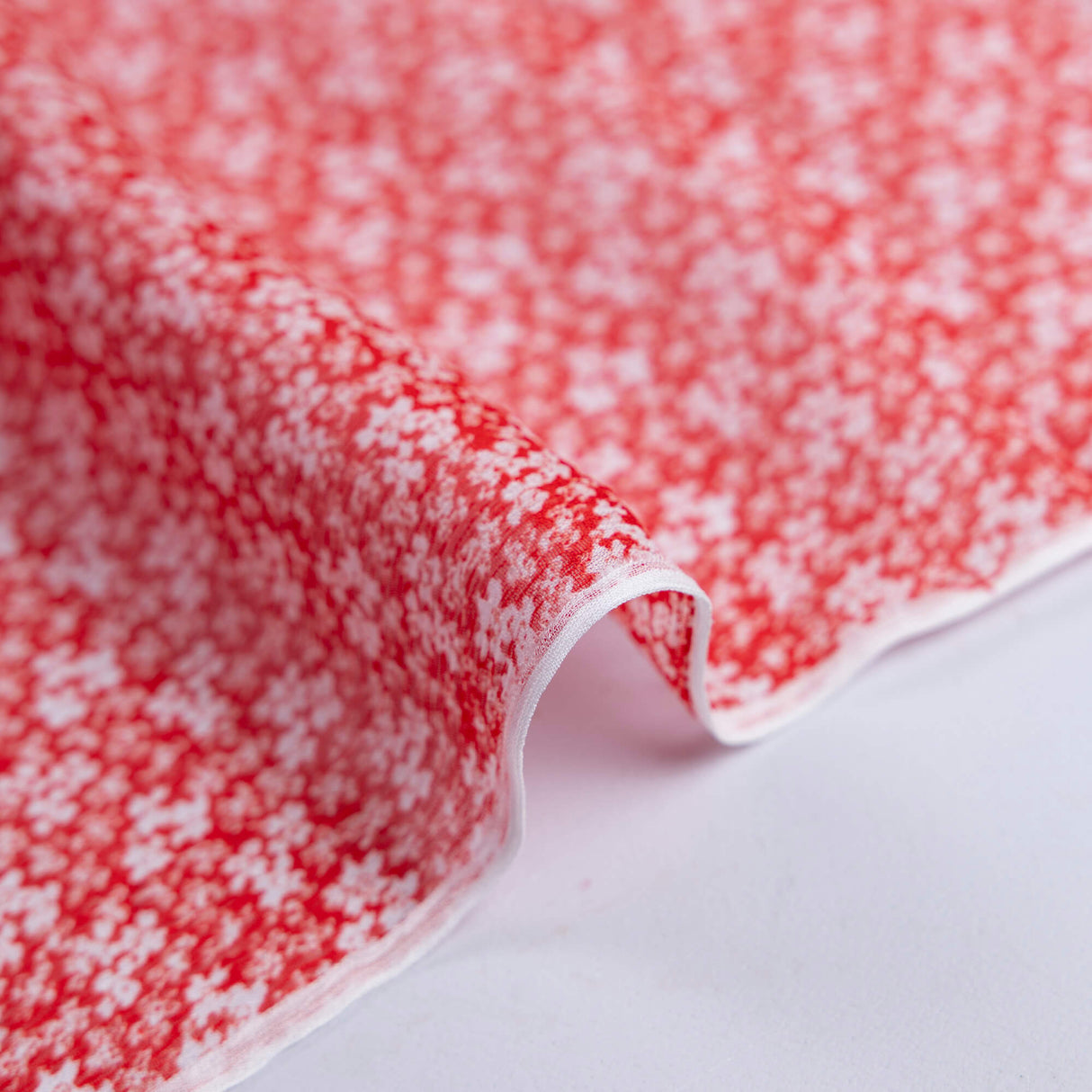Mousseline 100% viscose – Micro fleurs blanches fond rouge